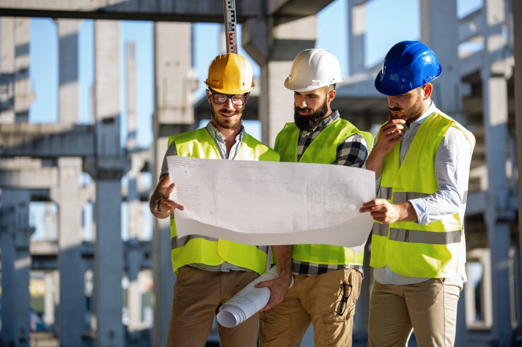 Construction engineers discussion with architects at construction or building site